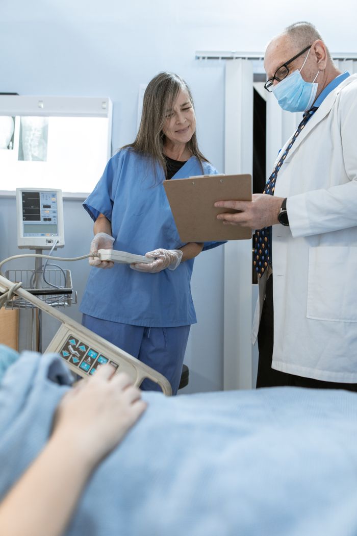 Home Doctor and nurse discussing patient care in a hospital setting